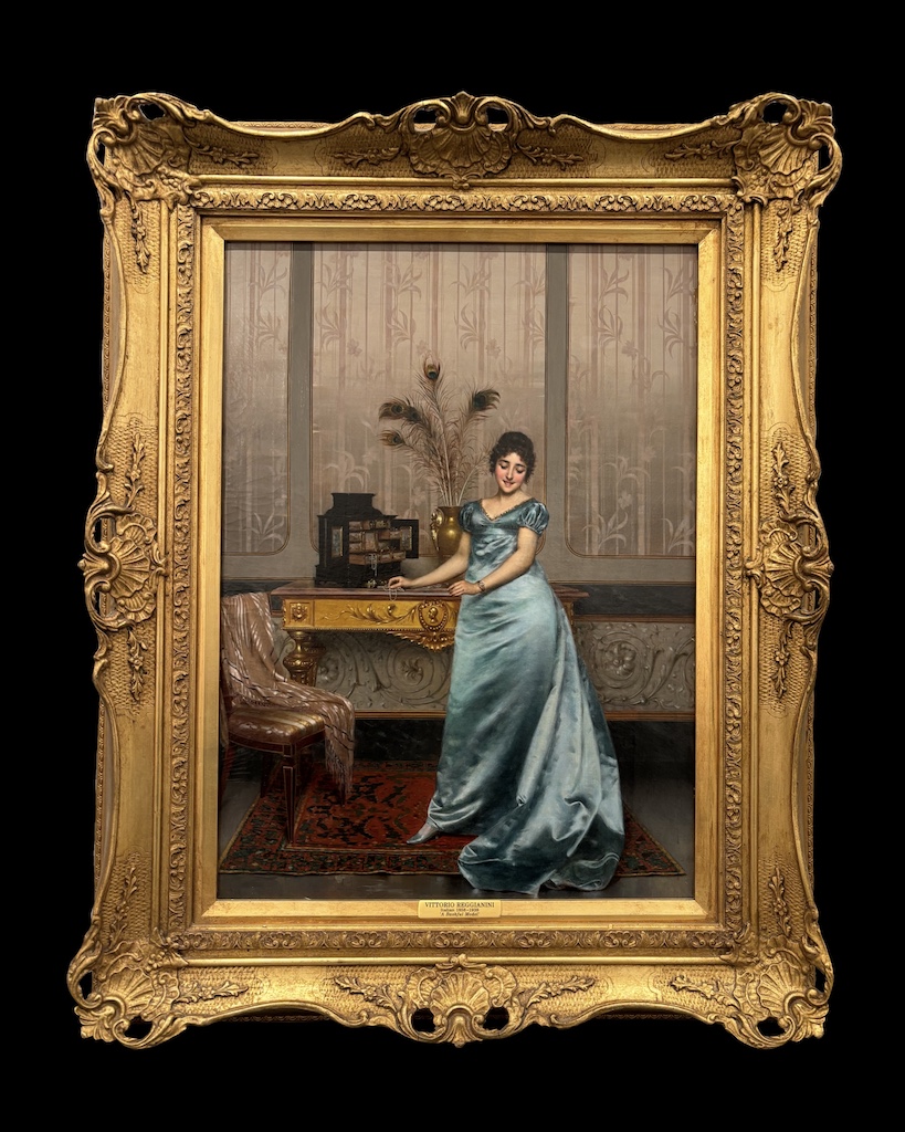 Bashful model by Vittorio Reggianini framed in a regal gold antique frame upon a black background.